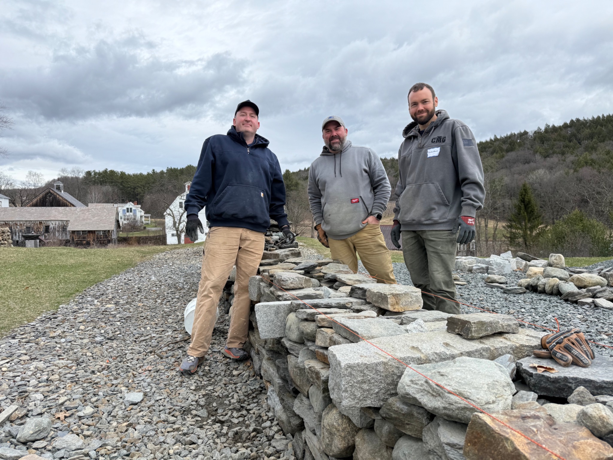 Project team beside a stone wall under construction